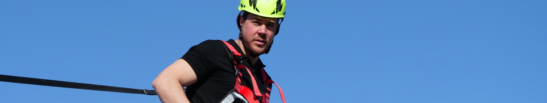 Fallsikring på tak Mann med fallsikringsele, sikring og hjelp på tak
